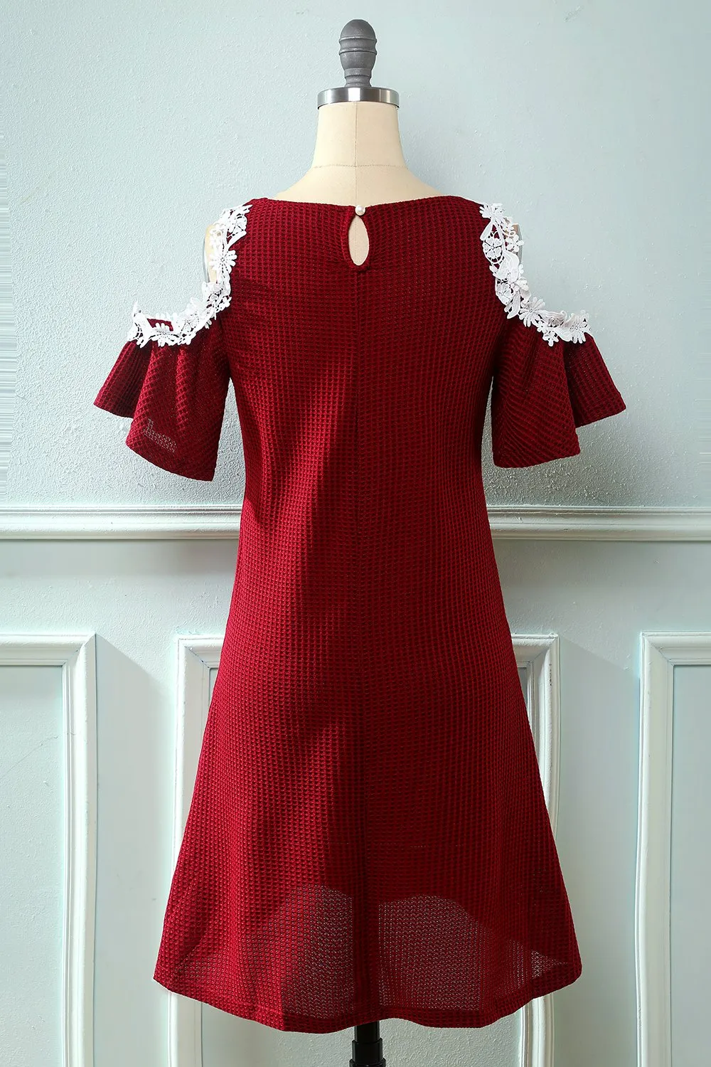 Abito in maglia rosso scuro fuori dalla spalla con applicazioni