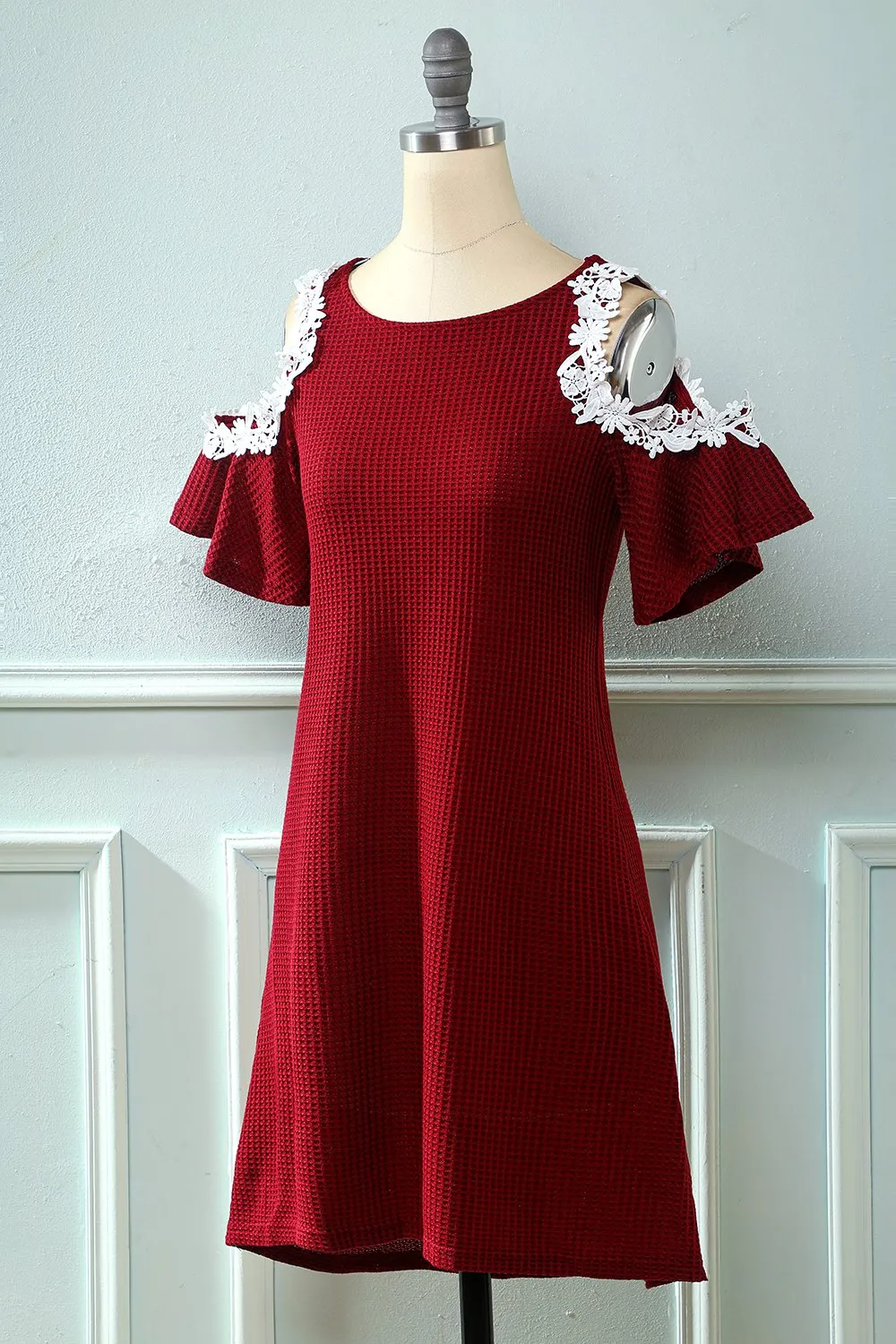 Abito in maglia rosso scuro fuori dalla spalla con applicazioni