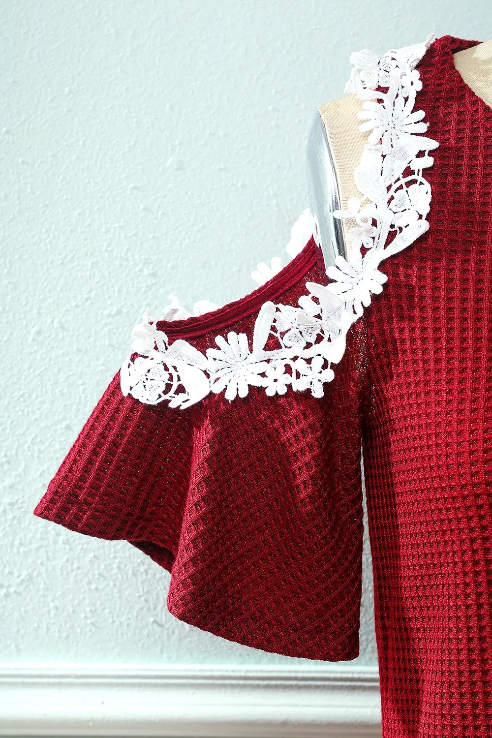 Abito in maglia rosso scuro fuori dalla spalla con applicazioni